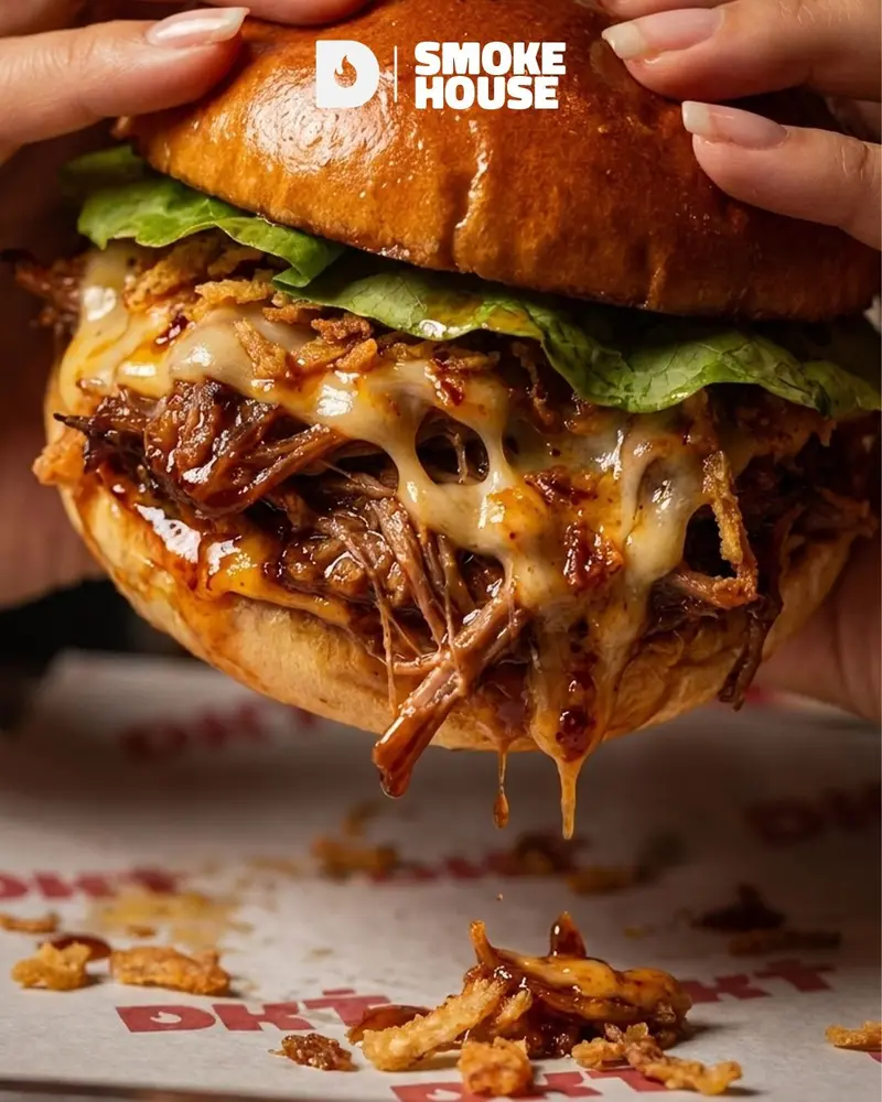 Burger con pulled pork desmechado y queso derretido sobre papel Dakota